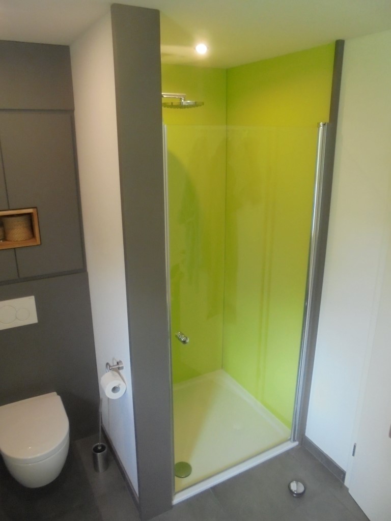 Bad mit bodengleicher Dusche und grüner Glaswand