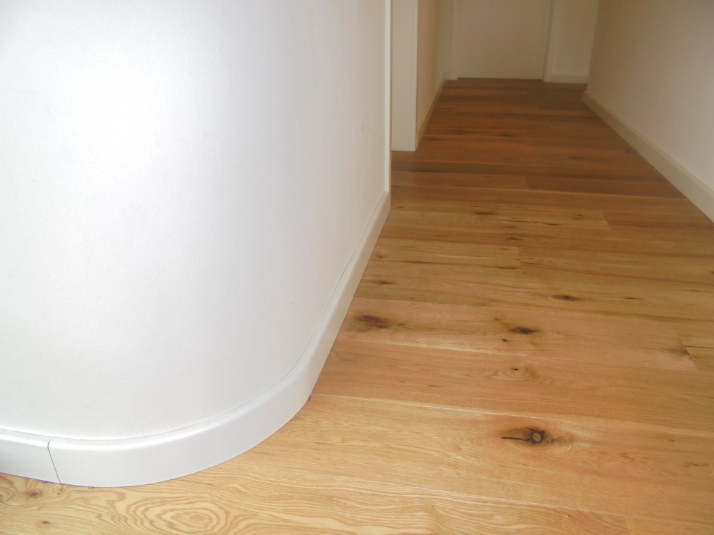 Frisch ausgebauter Raum mit Dielenboden und gerundeter Wandecke